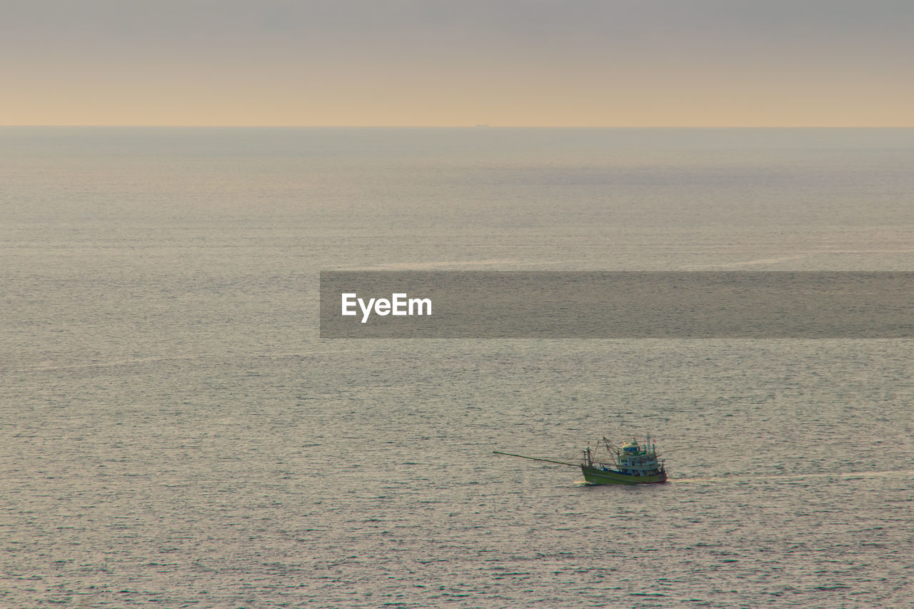 Boat sailing on sea against clear sky