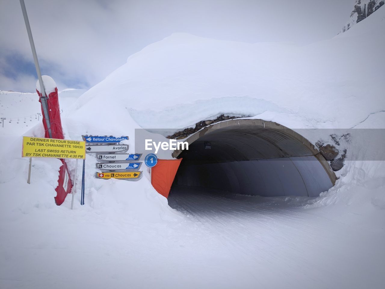 Snow covered tunnel with resort signage
