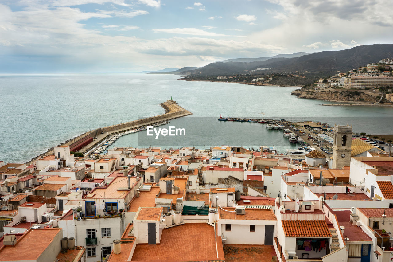 High angle view of townscape by sea against sky