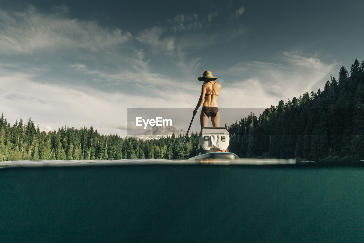 A young woman enjoys a standup paddle board on lost lake in oregon.