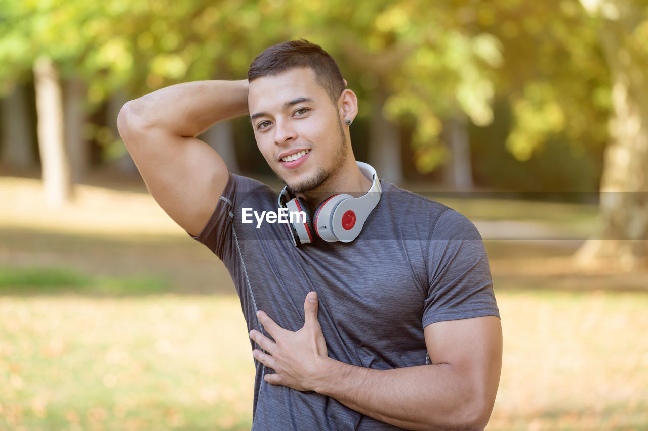 PORTRAIT OF HANDSOME YOUNG MAN STANDING ON FIELD