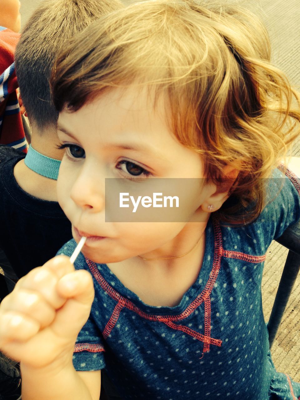 Close-up of cute girl having candy outdoors