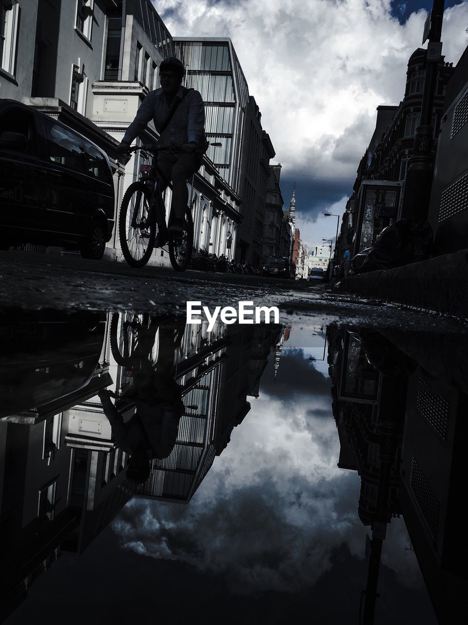 REFLECTION OF MAN IN WATER ON CITY