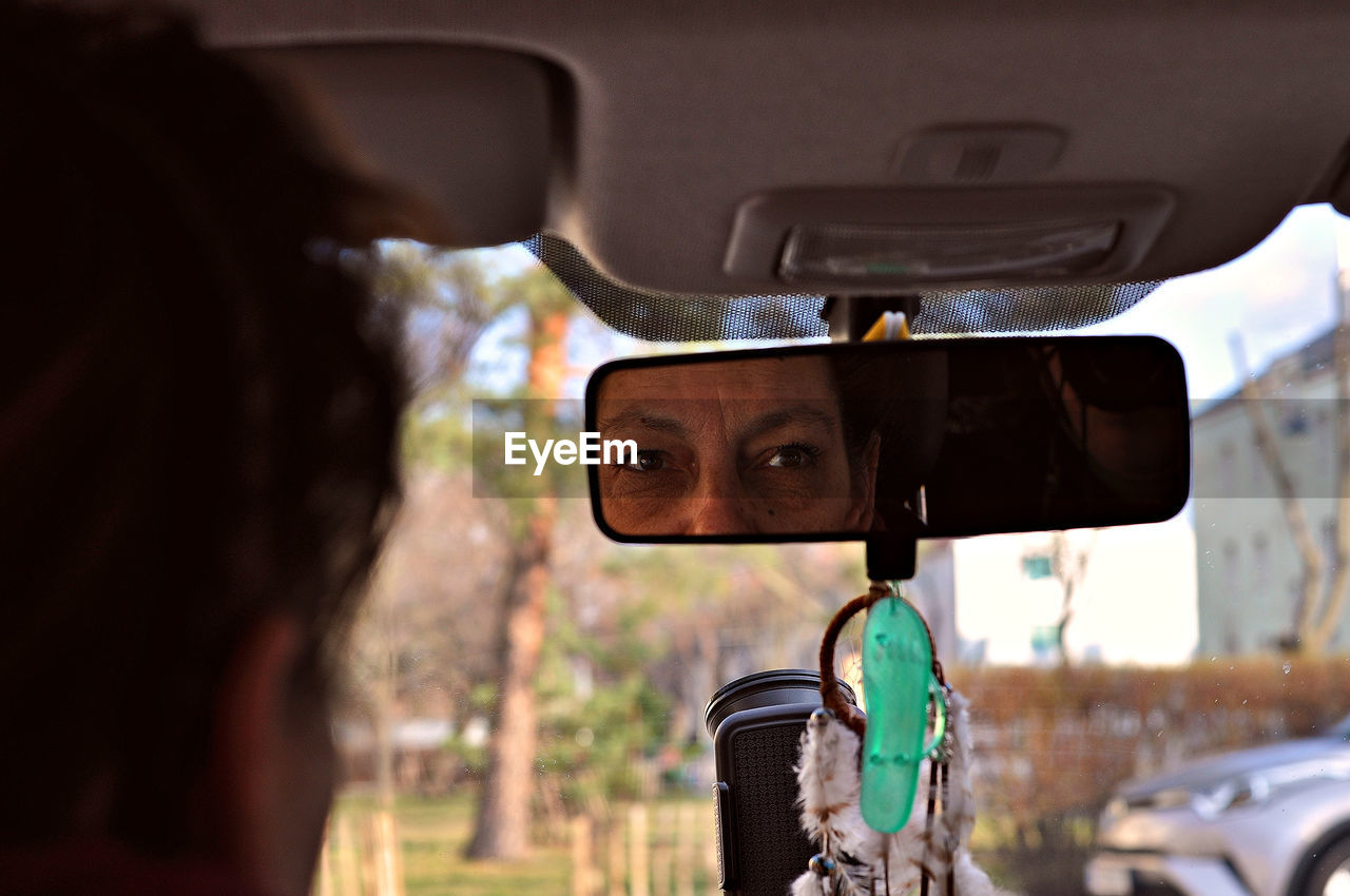 Close-up of woman looking in rear-view mirror