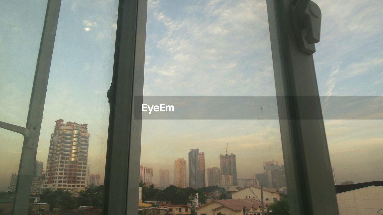 SKYSCRAPERS AGAINST CLOUDY SKY