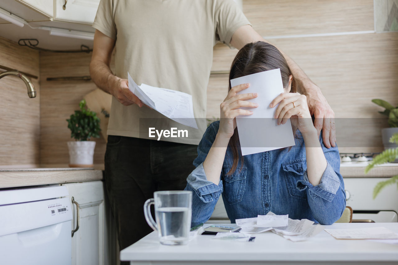 rear view of woman using mobile phone while sitting on table