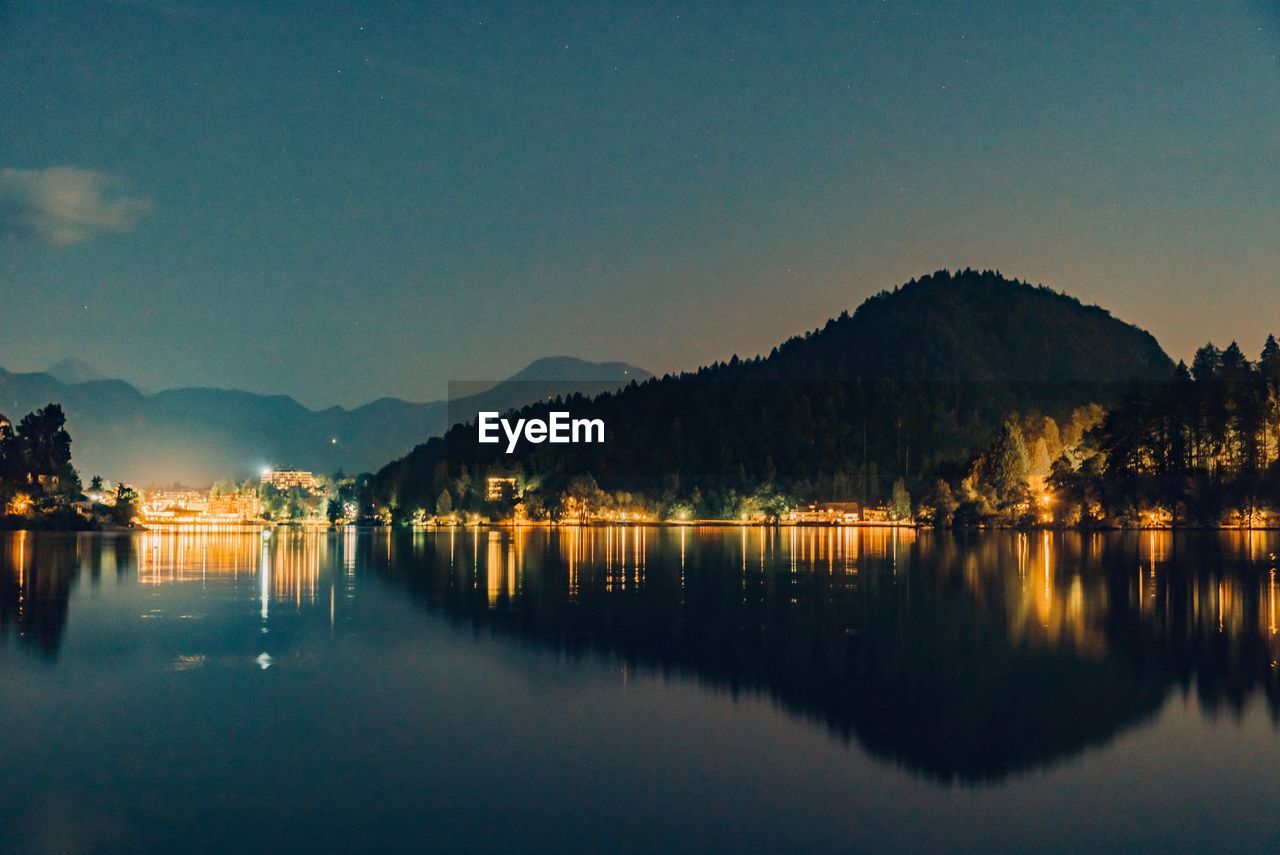 Scenic view of lake by mountains against clear sky