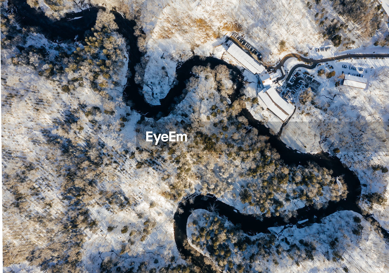 High angle view of river and houses snow covered field