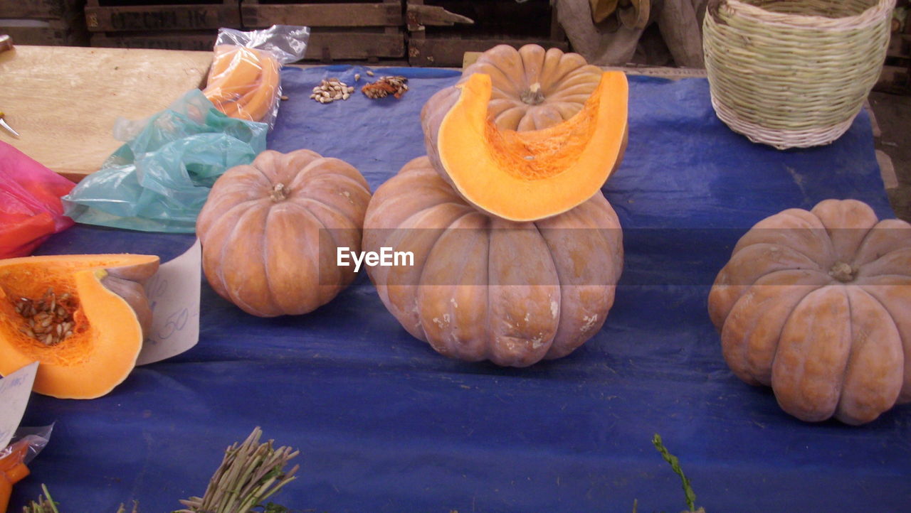 CLOSE-UP OF PUMPKINS ON TABLE AGAINST BRIGHT LIGHT