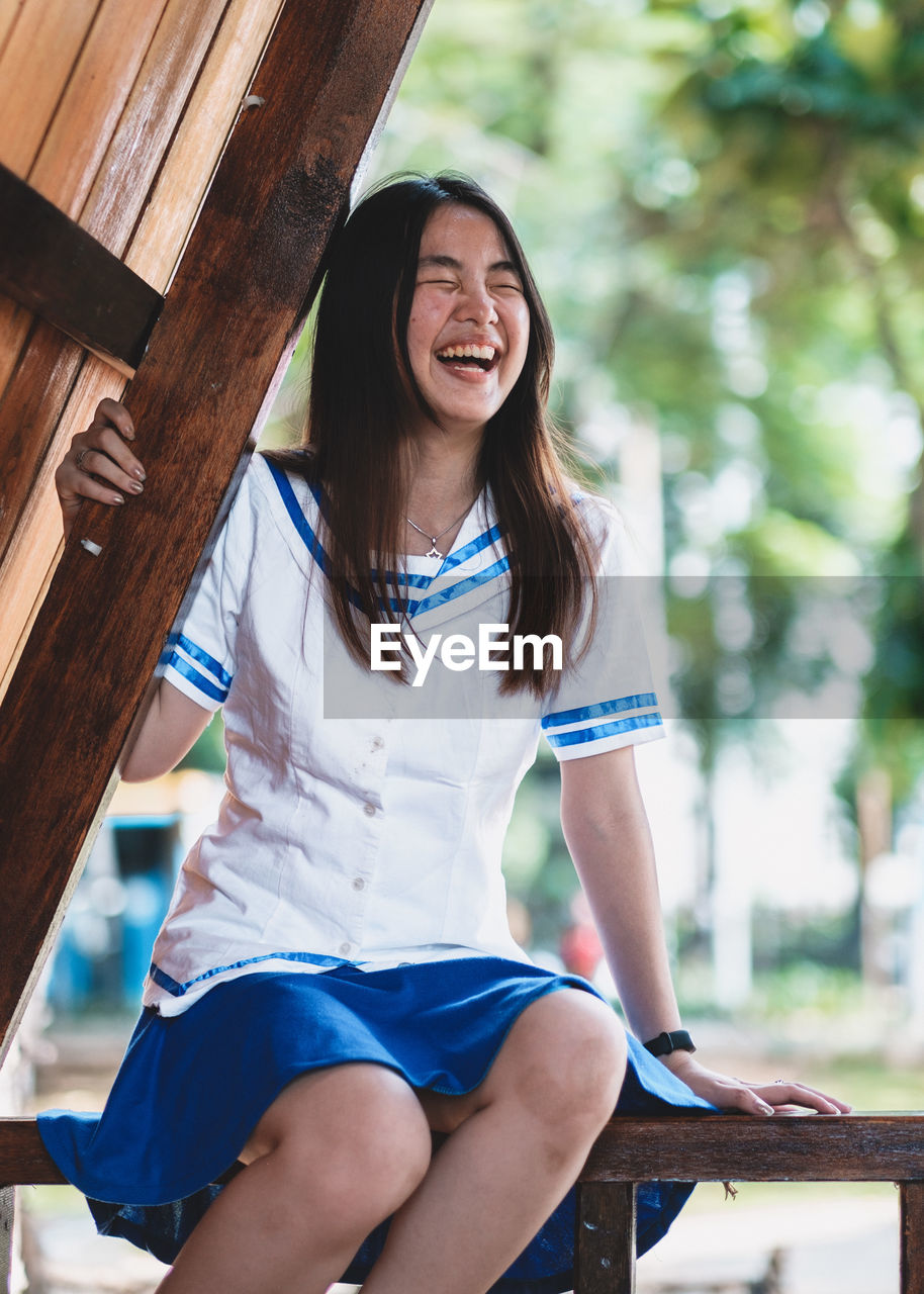 Young woman sitting on wood