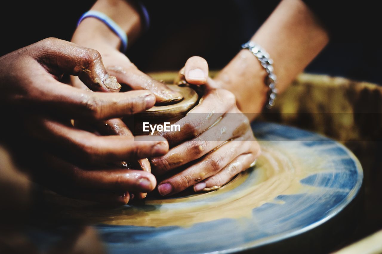 Close-up of hands working on pottery wheel