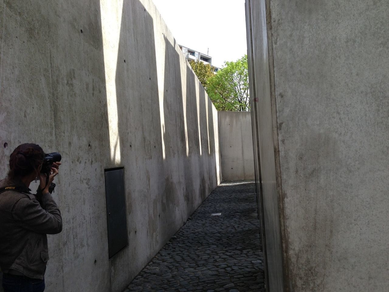 Woman photographing by wall