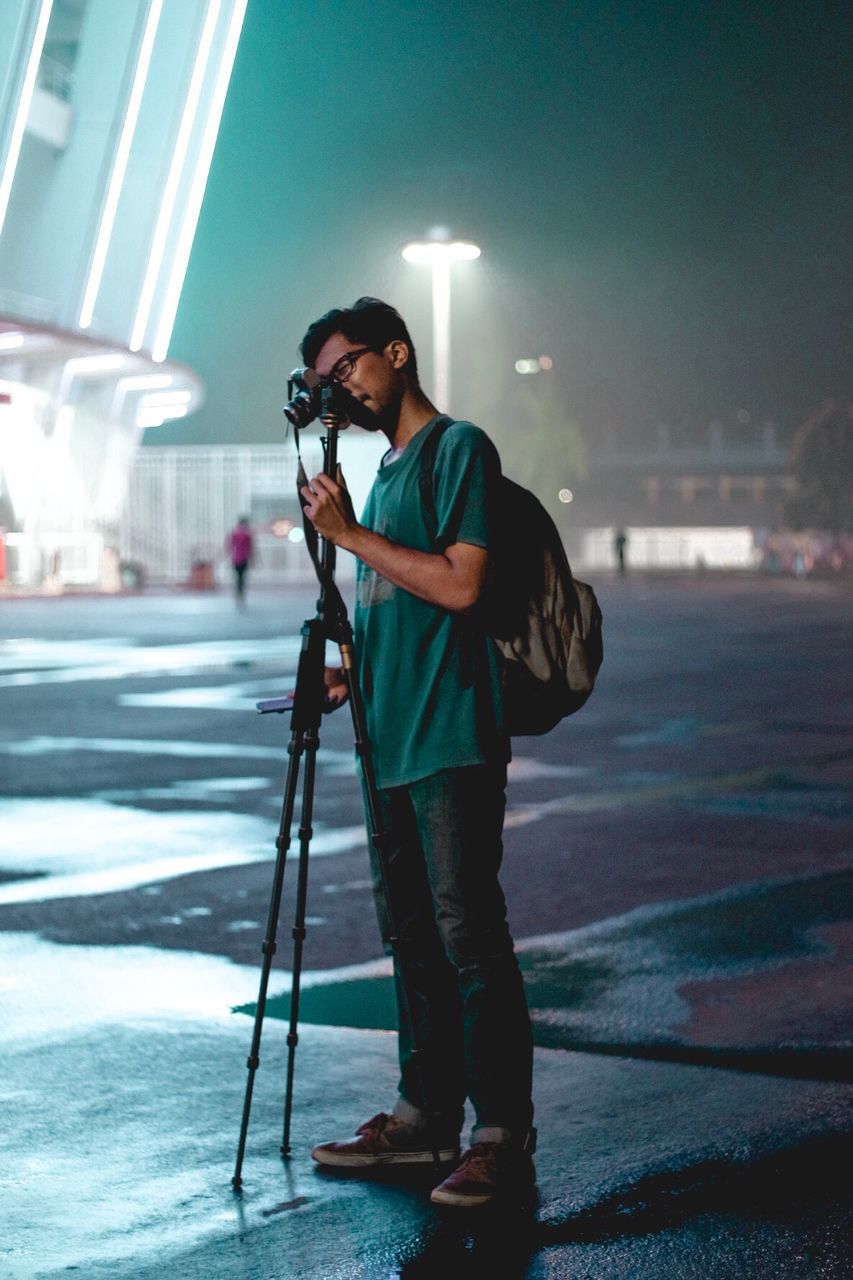 Full length of man photographing at night