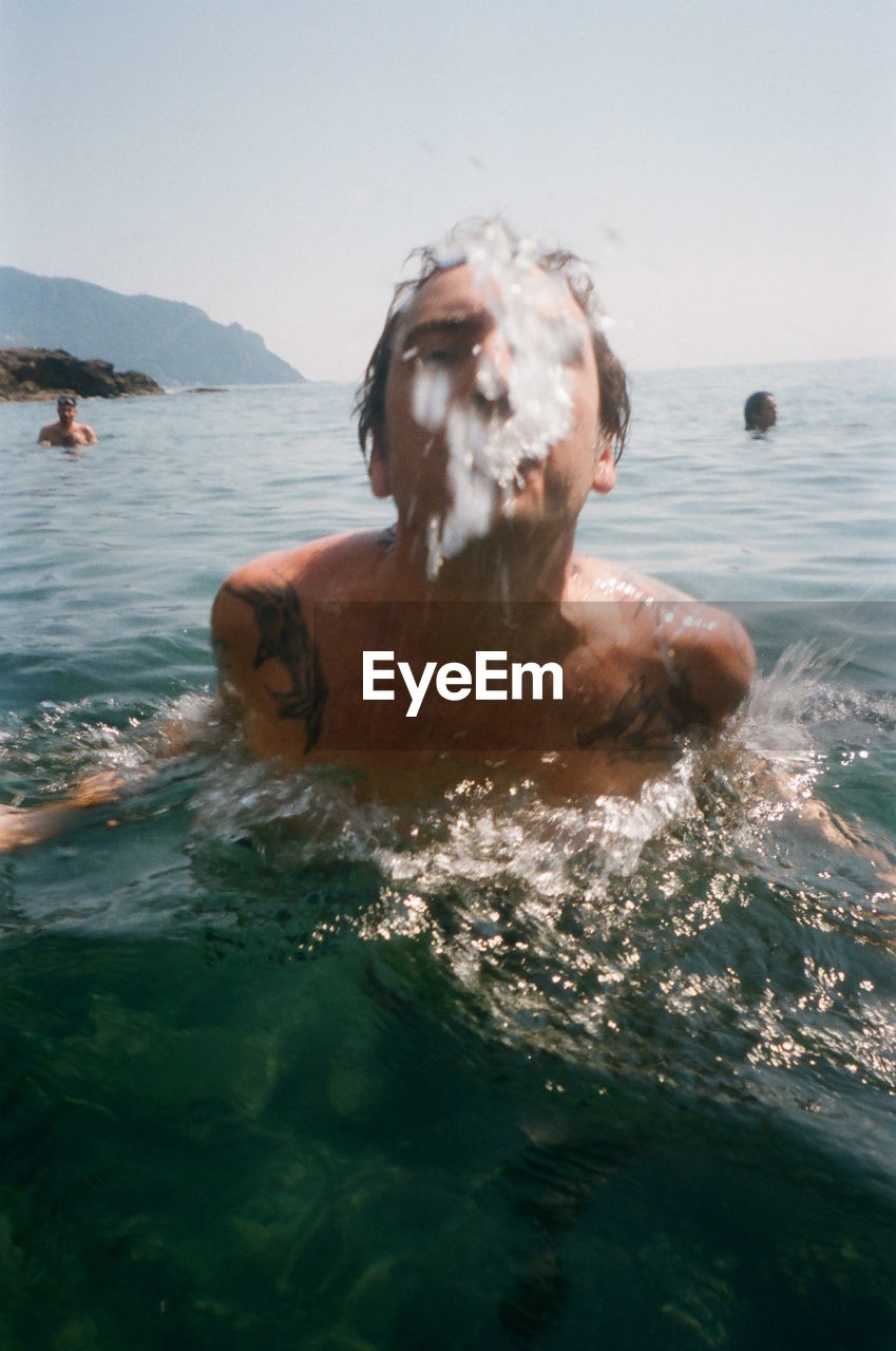 YOUNG MAN SWIMMING IN SEA