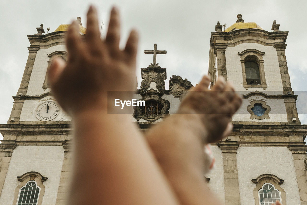 Cropped hands against church of nosso senhor do bonfim