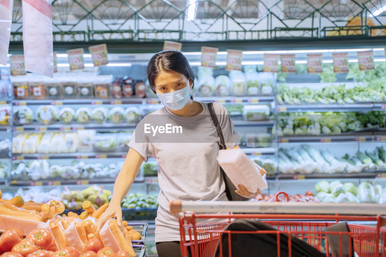 Portrait of woman wearing mask standing in shopping mall