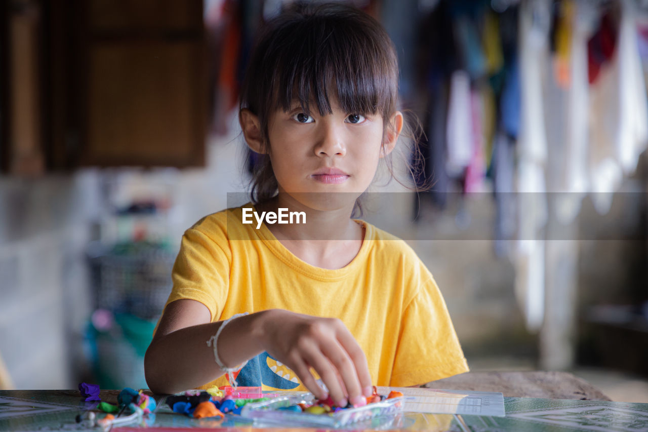 Portrait of cute girl playing with clay at home