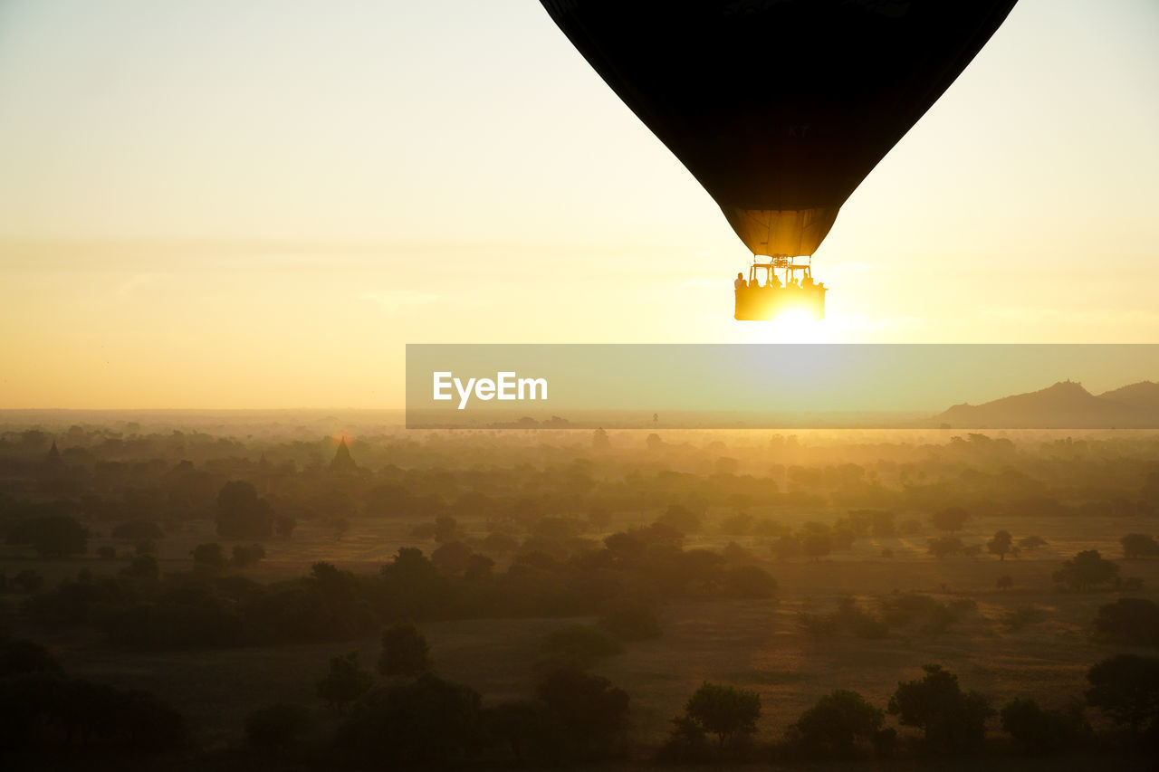Scenic view of hot air balloon landscape against sky during sunrise