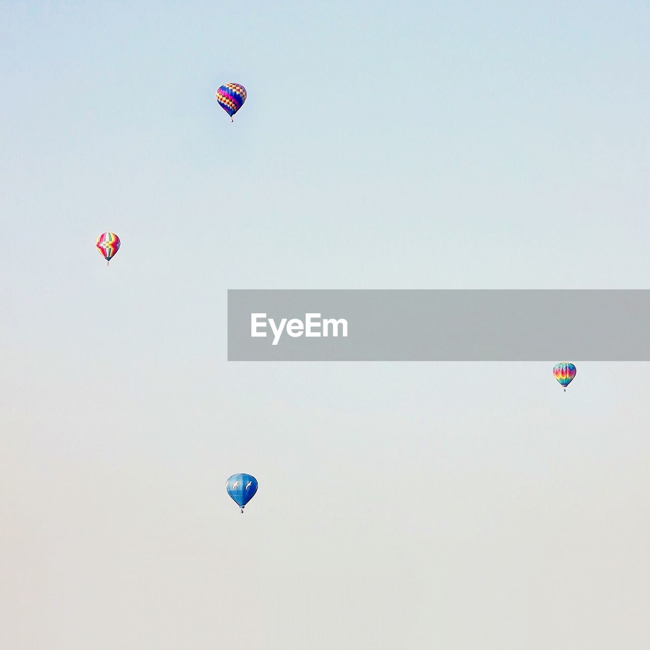 LOW ANGLE VIEW OF HOT AIR BALLOONS FLYING AGAINST CLEAR SKY