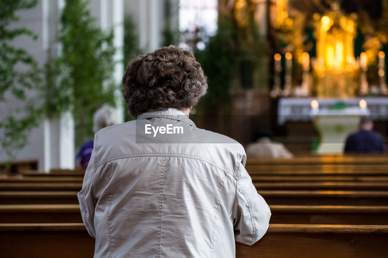 Rear view of woman sitting on bench in heiliggeistkirche