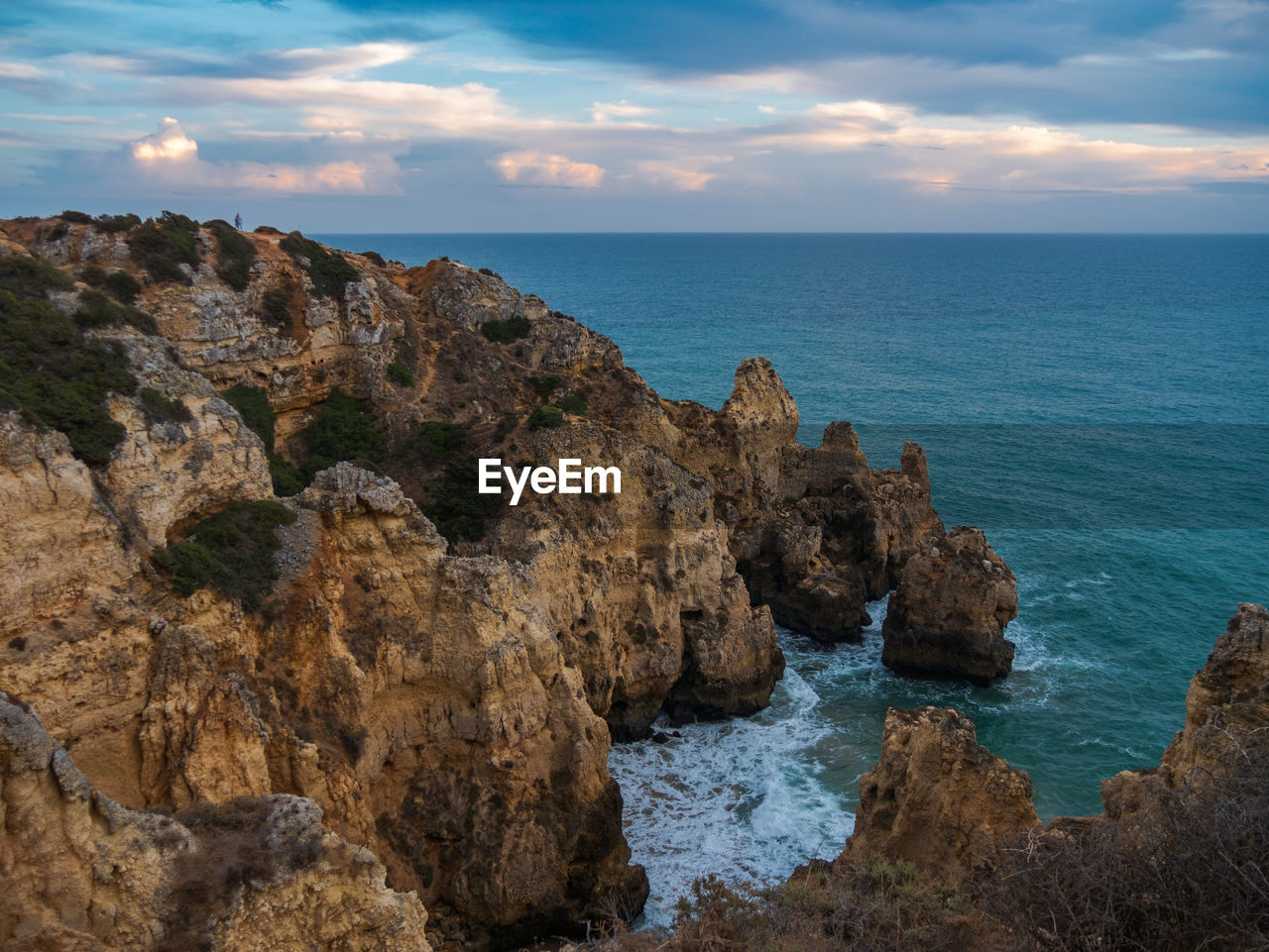 Rock formations by sea against sky