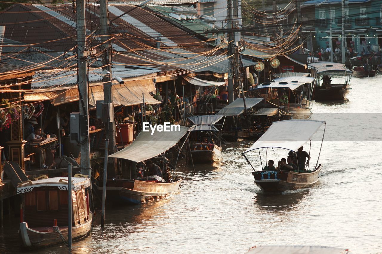 Sailboats moored on harbor in city