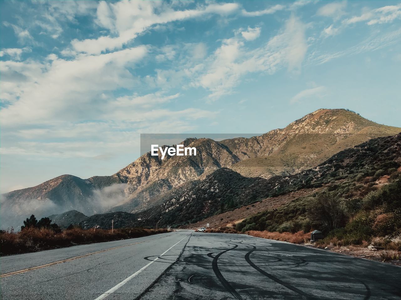 Road by mountain against sky