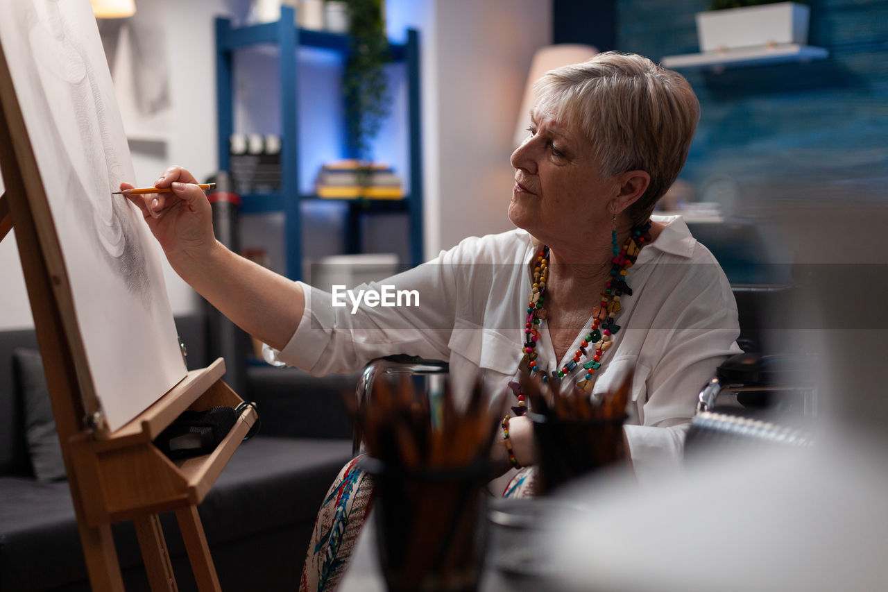 side view of young woman using mobile phone while sitting on table