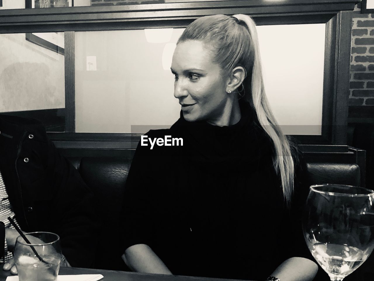 Smiling woman looking away while sitting in restaurant