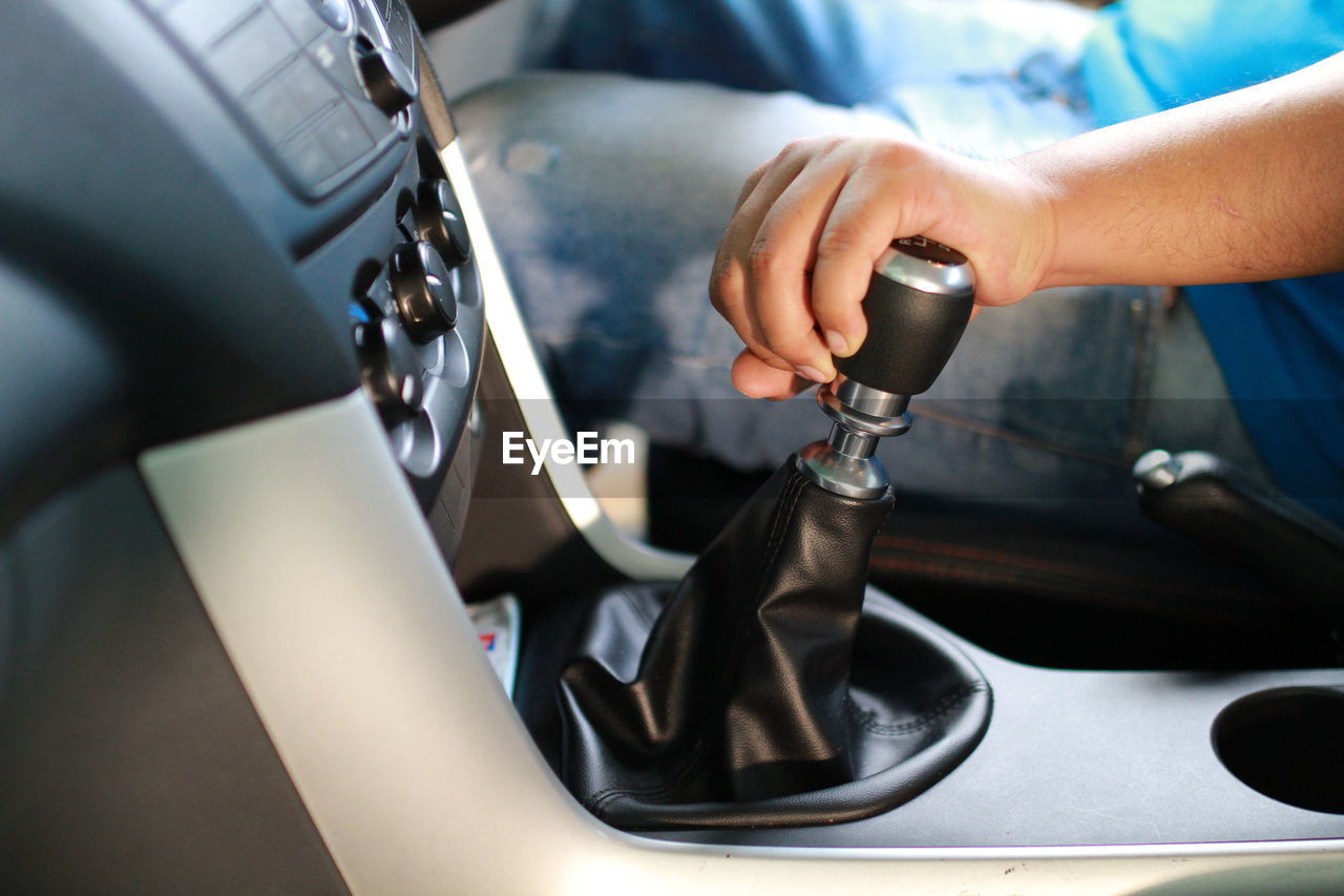 Midsection of man holding gear while driving car