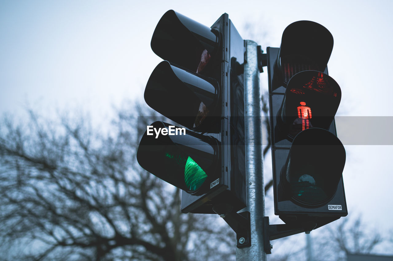 Low angle view of road signal against sky