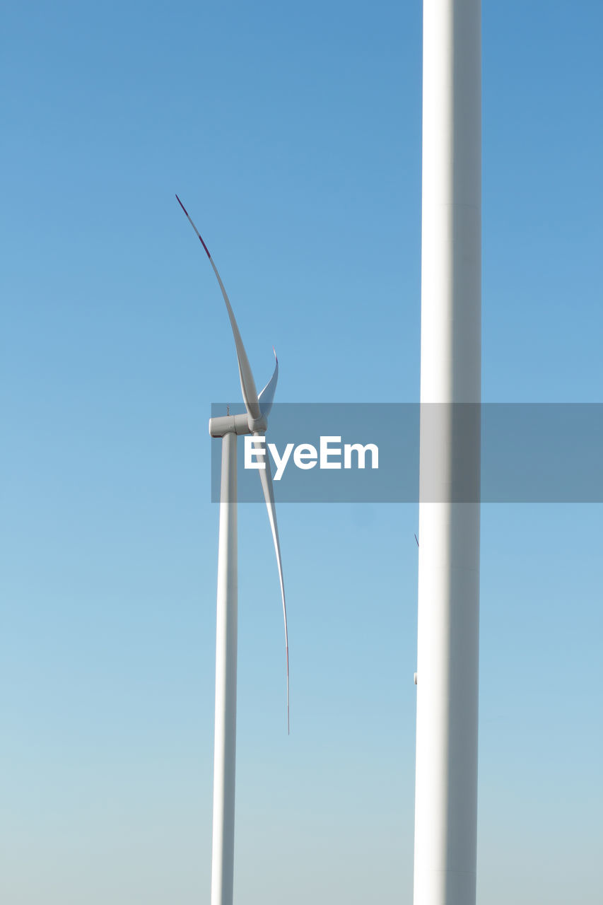 LOW ANGLE VIEW OF WINDMILL AGAINST CLEAR BLUE SKY