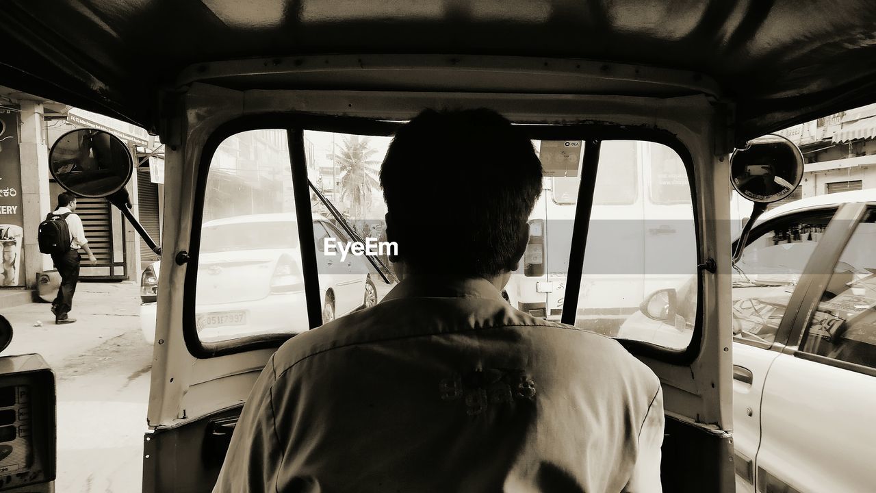 REAR VIEW OF A MAN IN VEHICLE