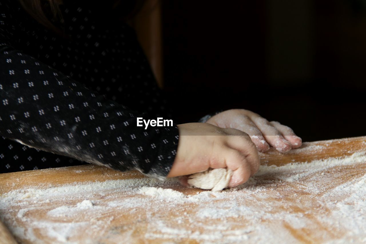 Close-up of hands kneading dough