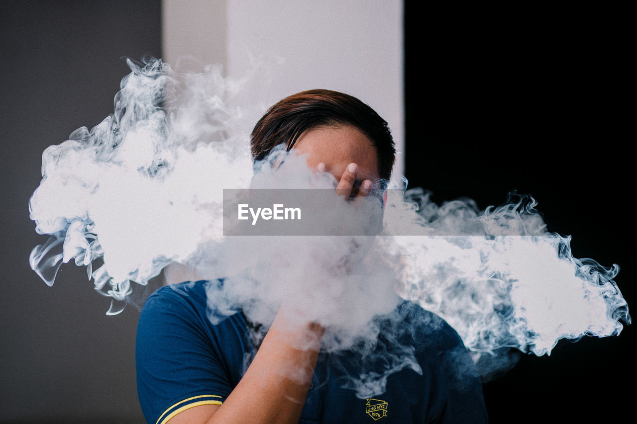 FULL LENGTH PORTRAIT OF MAN SMOKING