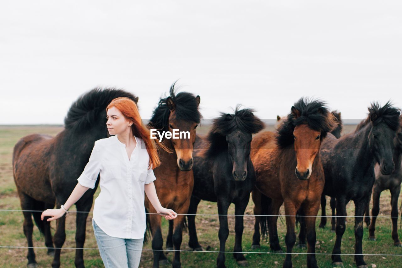 Woman standing by horse