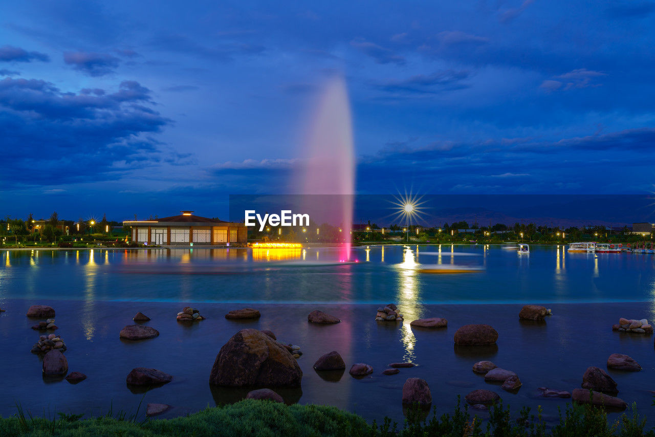 high angle view of city by lake against sky