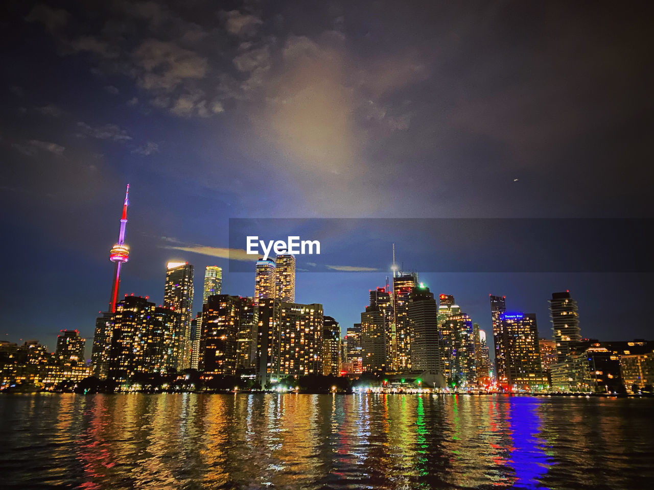 Illuminated buildings in city against sky at night