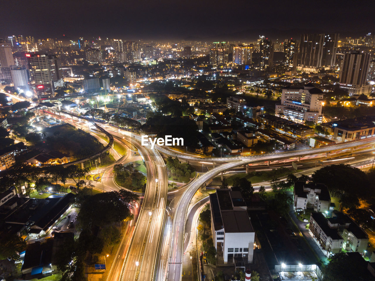 HIGH ANGLE VIEW OF ILLUMINATED CITY BUILDINGS AT NIGHT