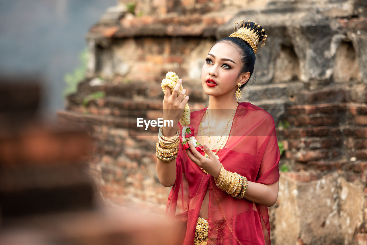 PORTRAIT OF A YOUNG WOMAN WITH TEMPLE IN BACKGROUND