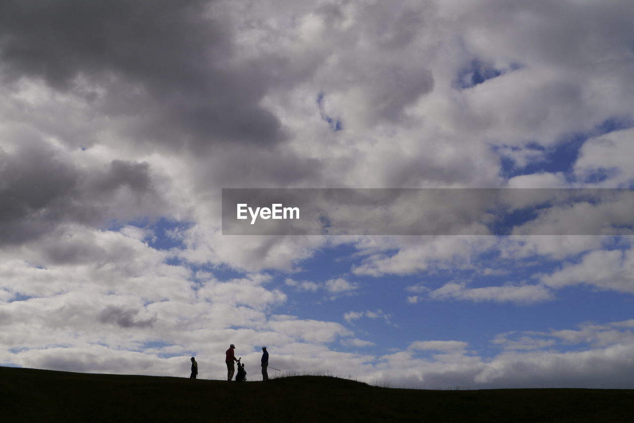 SILHOUETTE MEN STANDING AGAINST CLOUDY SKY