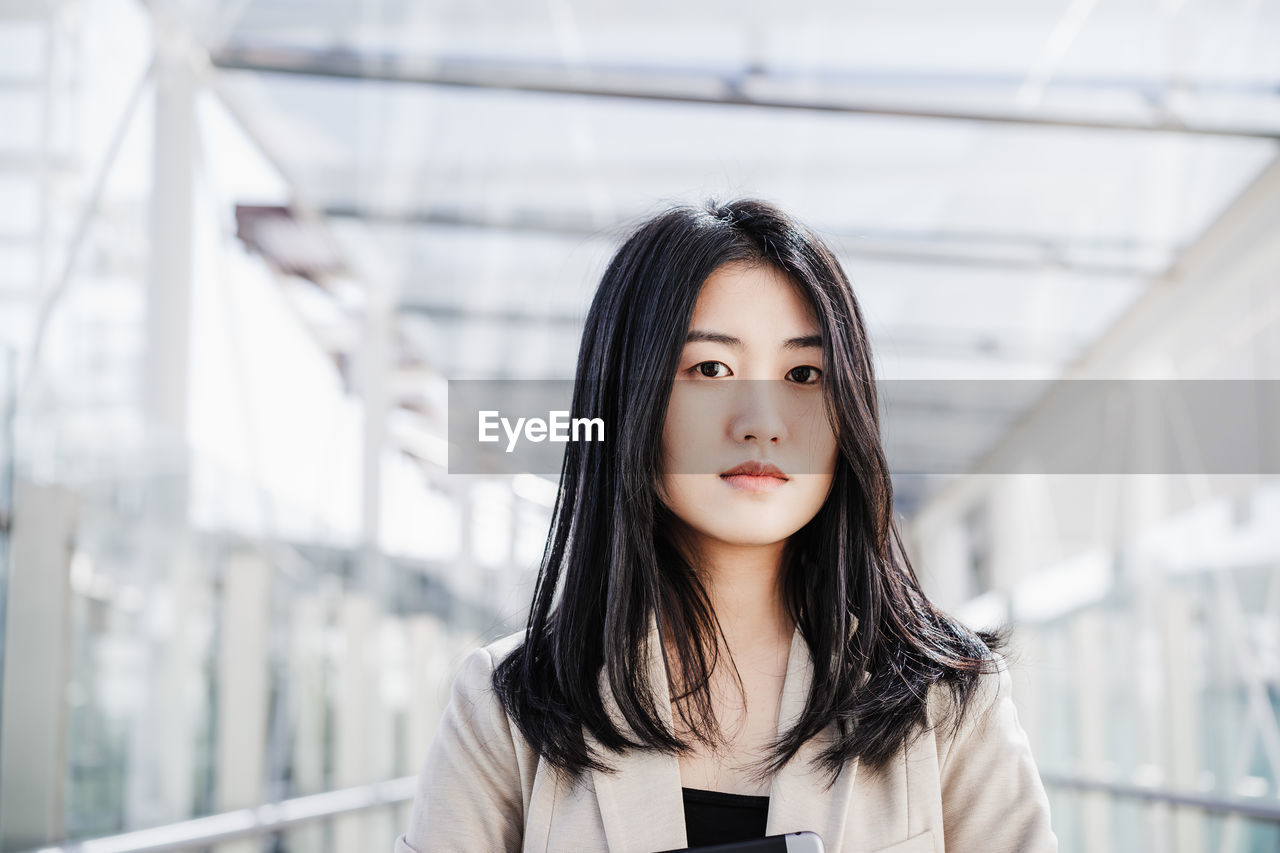 Portrait of confident chinese business woman in building office. technology