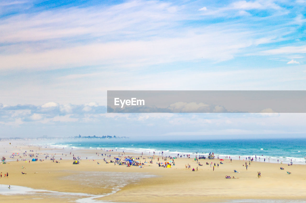 PEOPLE AT BEACH AGAINST SKY