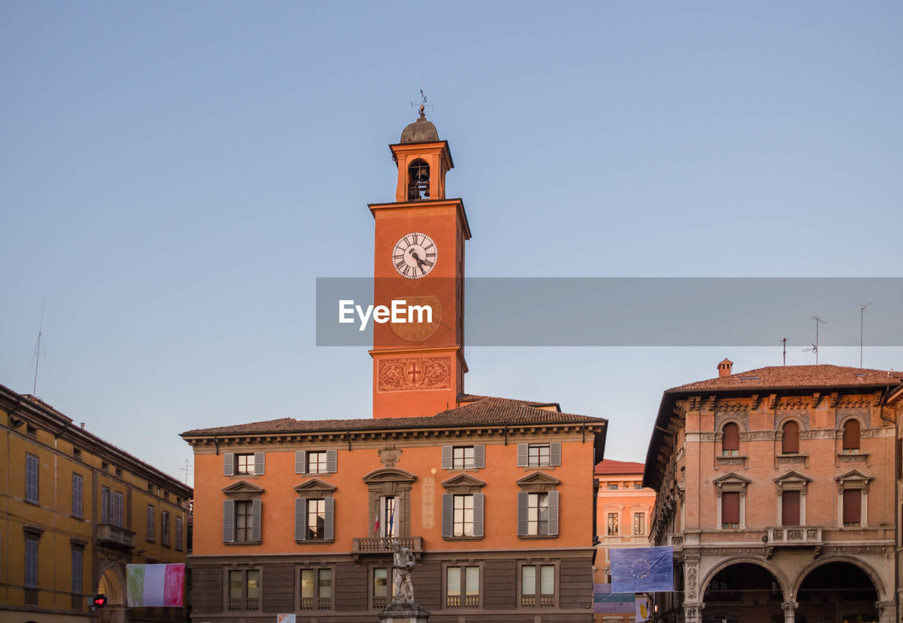 architecture, clock, building exterior, built structure, landmark, town, tower, clock tower, building, travel destinations, city, time, sky, history, the past, nature, town square, travel, downtown, clear sky, tourism, clock face, plaza, bell tower, blue, sunny, cityscape, arch, no people, street, old, religion, day, place of worship, outdoors, facade