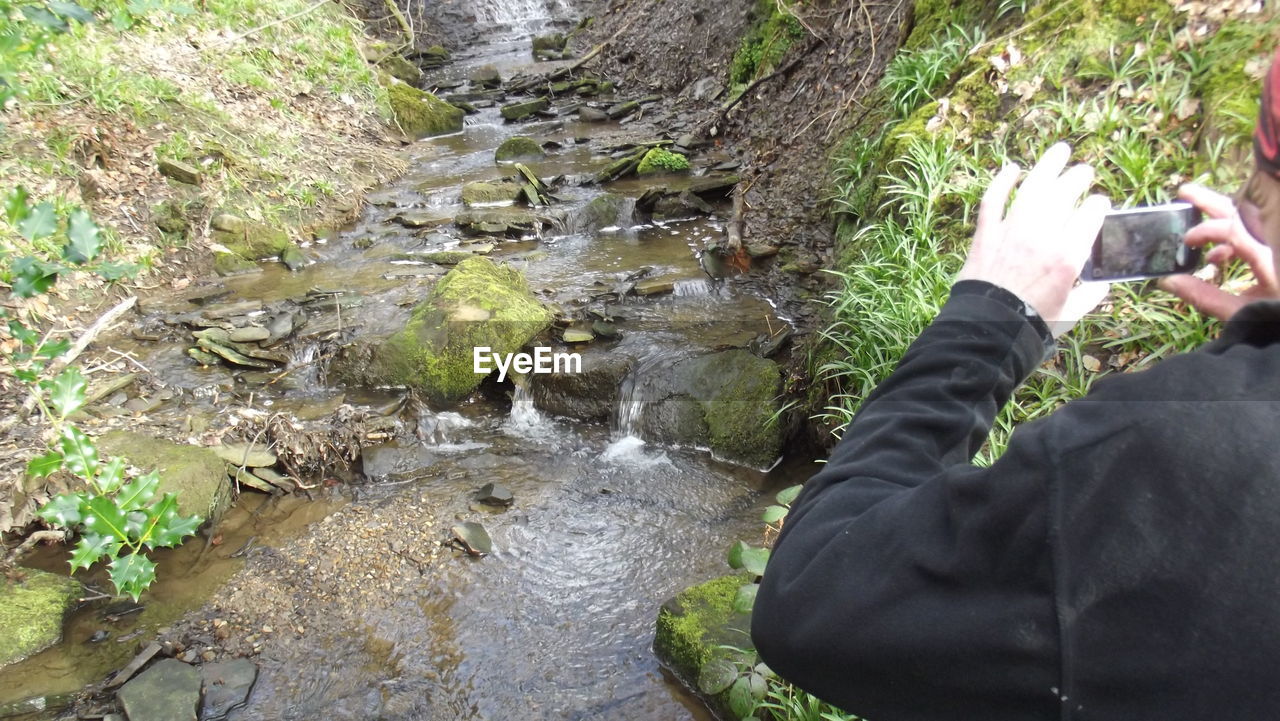 Hands photographing stream with mobile phone