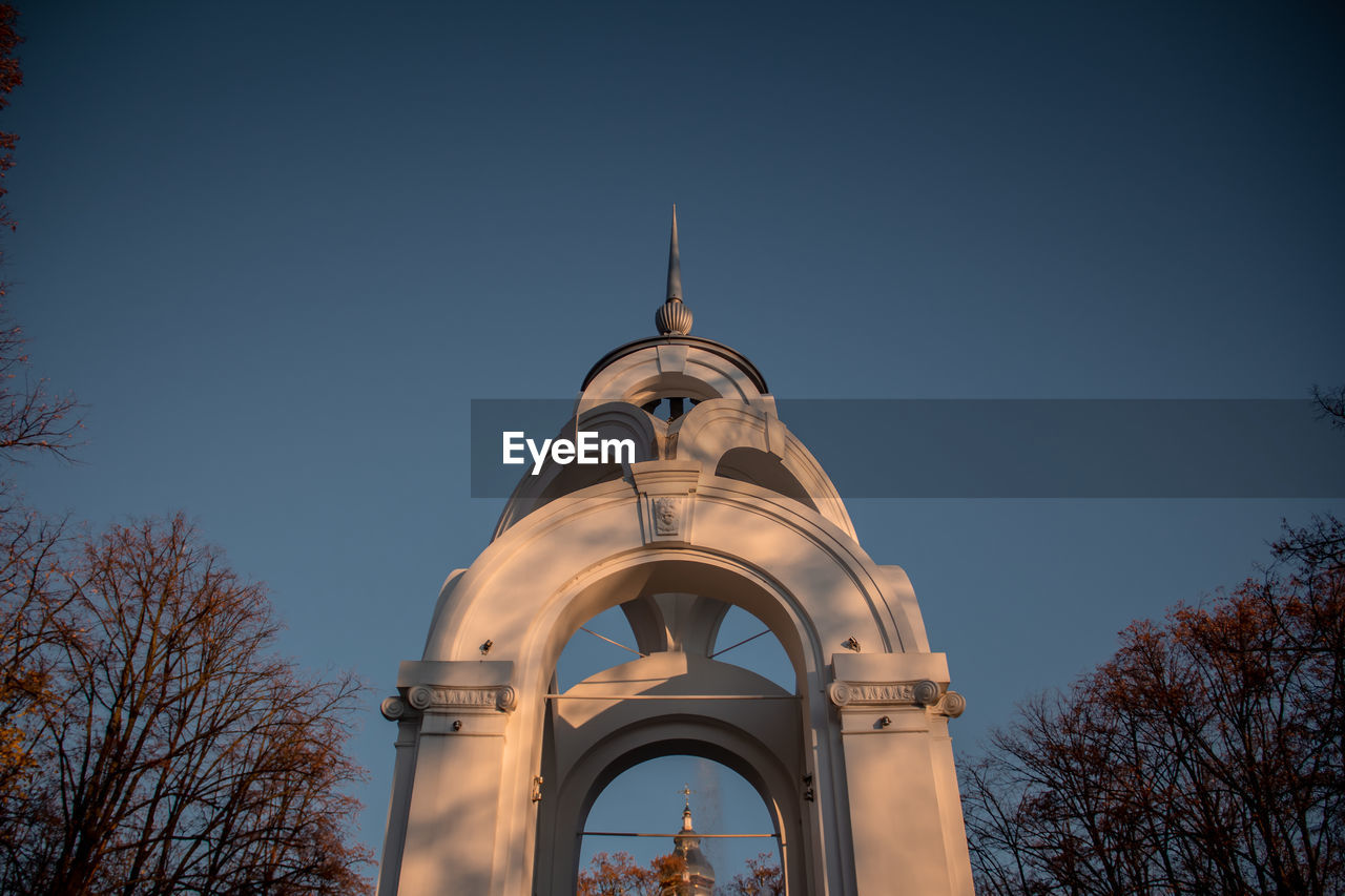 Low angle view of bell tower against blue sky