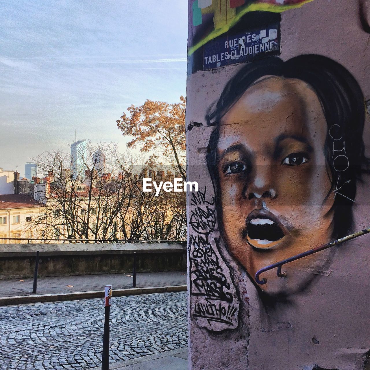 CLOSE-UP PORTRAIT OF YOUNG WOMAN AGAINST SKY