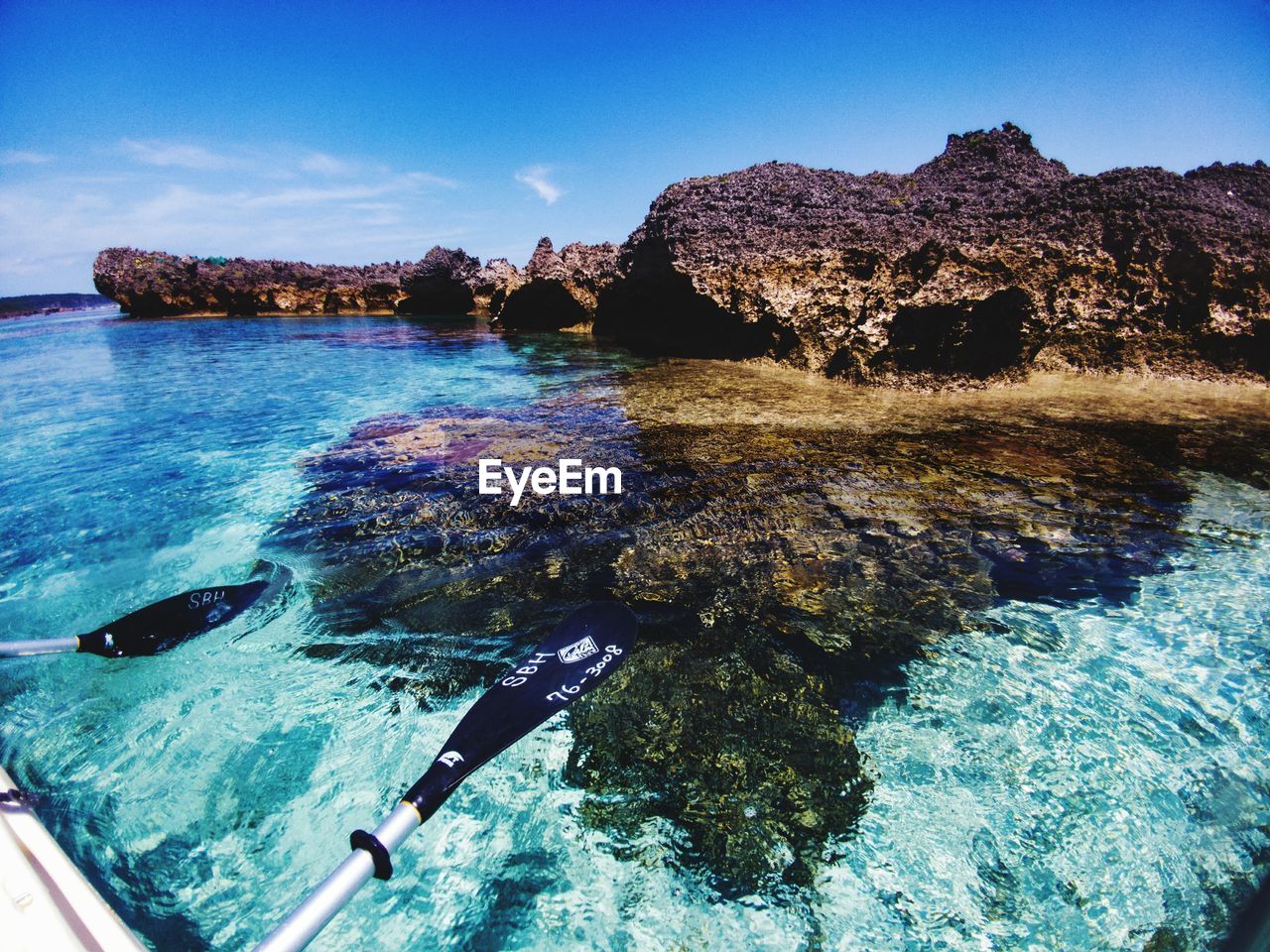 Rock formations in sea against blue sky