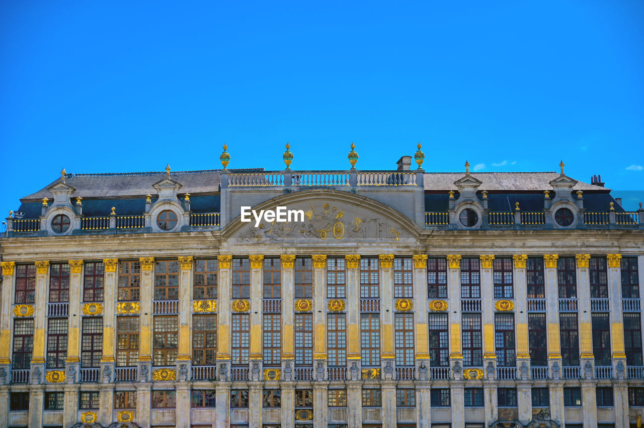 LOW ANGLE VIEW OF BUILDINGS AGAINST BLUE SKY