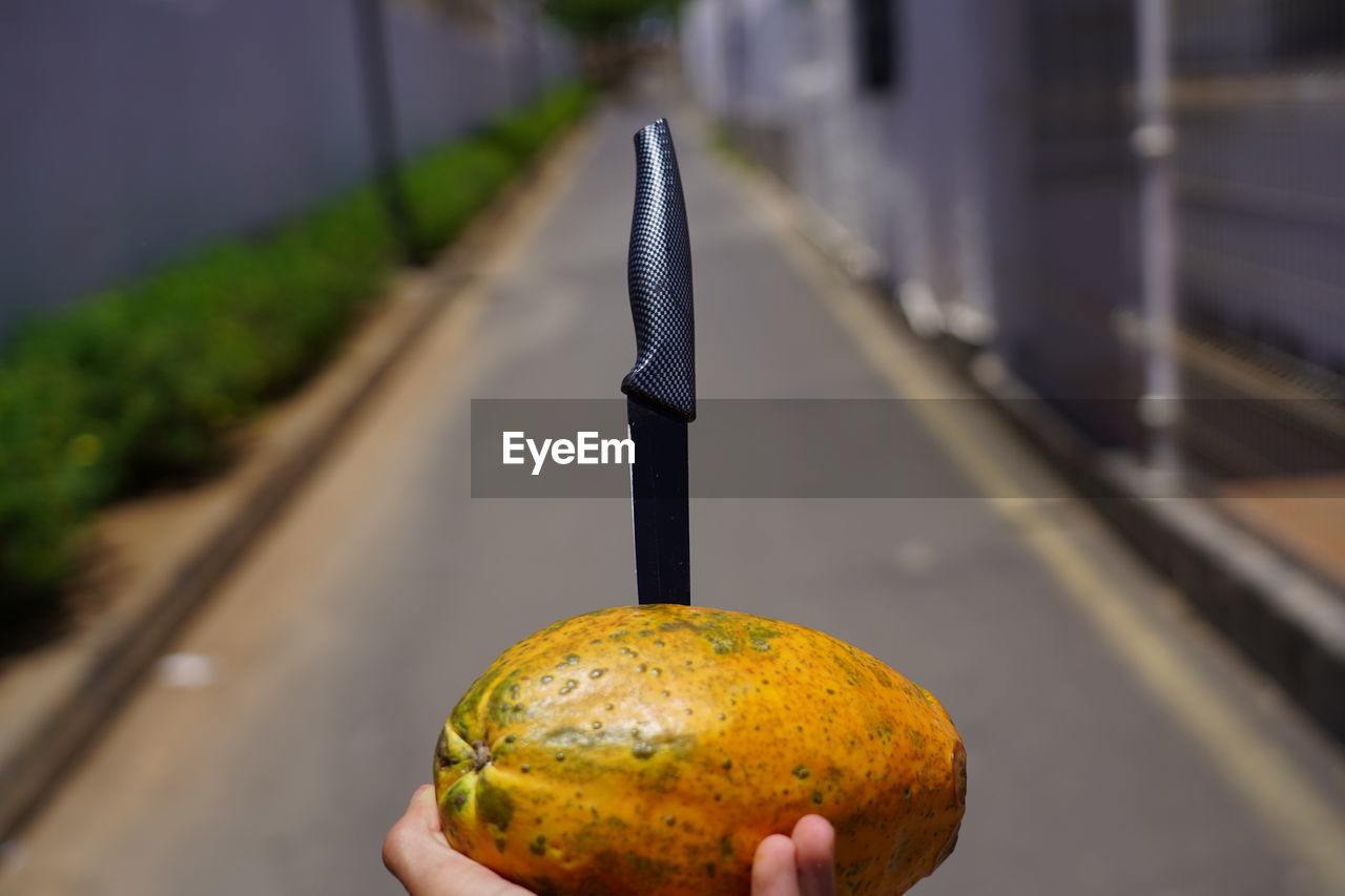 CLOSE-UP OF A HAND HOLDING BANANA